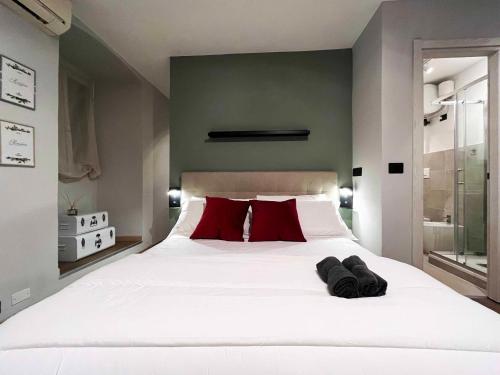 a bedroom with a large white bed with red pillows at Giano Host - Capro in Genova