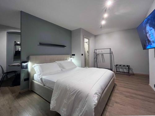 a bedroom with a white bed and a flat screen tv at Giano Host - Capro in Genova