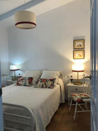 a bedroom with a bed and two tables and a lamp at El Granado in Piedrabuena