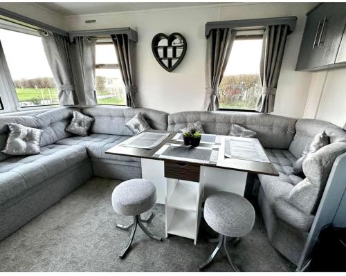 a living room with a couch and a table and chairs at Hazel grove - Withernsea Sands in Waxholme