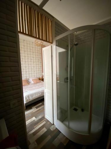 Il comprend une chambre et une salle de bains pourvue d'une douche en verre. dans l'établissement GRAND APPARTEMENT DE STYLE HAUSSMANNIEN, à Boulogne-sur-Mer