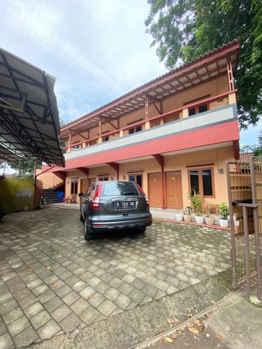 a car parked in front of a house at Karina Guest House Syariah in Tangkil