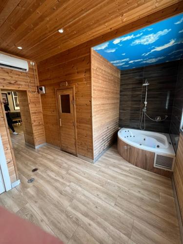 a large bathroom with a tub in a room with wooden walls at רויאל חדרי אירוח - באר שבע - Royal in Beer Sheva