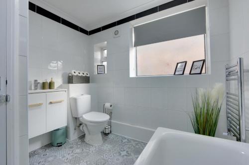 Baño blanco con aseo y lavamanos en Cozy 2-bedroom house in Sheffield en Tankersley