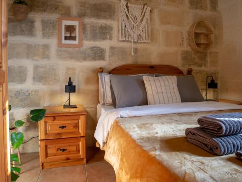 a bedroom with a bed and a table with a night stand at Sunny Villa in Nadur