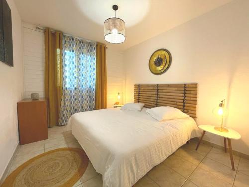 a bedroom with a large white bed and a window at Les Gîtes du Petit Mas in Lagamas