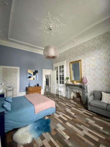 une chambre avec un lit, un canapé et une cheminée dans l'établissement GRAND APPARTEMENT DE STYLE HAUSSMANNIEN, à Boulogne-sur-Mer