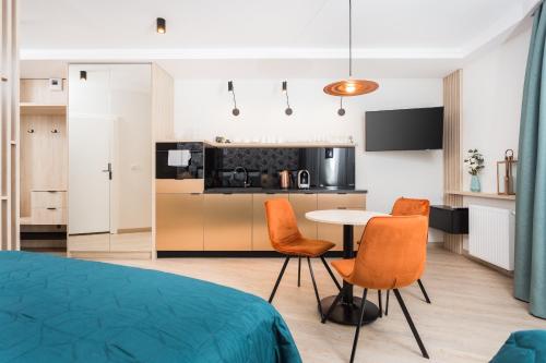a room with a kitchen and a table and chairs at InPoint Central Apartments in Kraków
