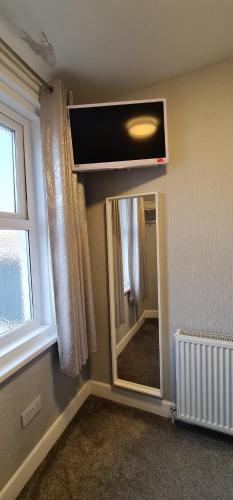 a room with a mirror and a television on the wall at Ocean Bay in Blackpool