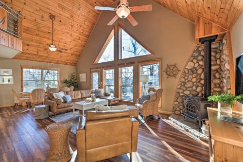 a living room with a ceiling fan and a fireplace at Pet-Friendly Grand Lake House with Dock and Kayaks! in Eucha