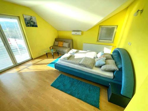 a bedroom with a bed in a room with yellow walls at Haus mit großen Garten in Modriča