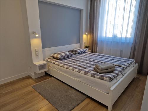 a bedroom with a bed with pillows on it at Apartament Baltic Park - BEL MARE in Pogorzelica
