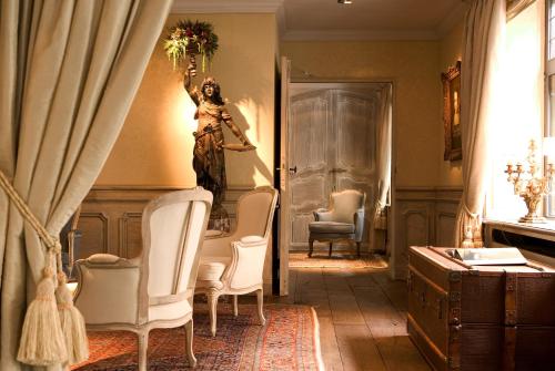 a painting of a woman sitting on a chair in a living room at Relais Bourgondisch Cruyce, A Luxe Worldwide Hotel in Bruges