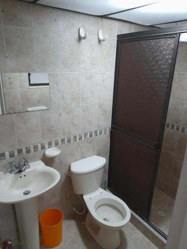 y baño con aseo, lavabo y ducha. en Mi hospedaje, en Bogotá