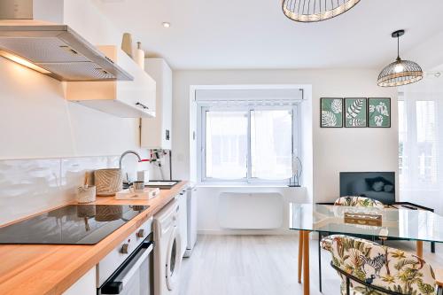 une cuisine blanche avec un évier et un comptoir dans l'établissement Little Jungle - T2 avec parking, à Vierzon