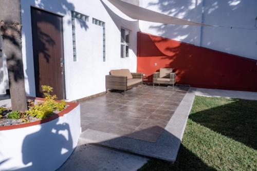 a patio with two chairs and a building at Tu cabaña Cuernavaca - hospedaje by Arcadia in Cuernavaca