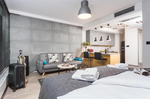 a bedroom with two beds and a living room at InPoint Central Apartments in Kraków