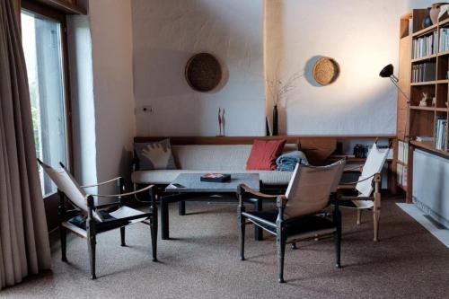 a living room with a couch and chairs and a table at La Stalla - Mid-Century Rustico in Calpiogna