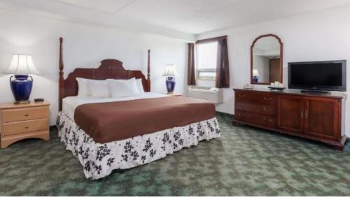 a bedroom with a large bed and a flat screen tv at Best Stay Inn in Melville