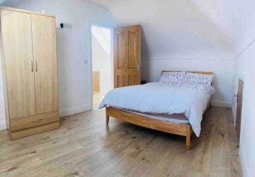 um quarto com uma cama e um armário de madeira em Teach Dunmore in the heart of Donegal Gaeltacht. em Falcarragh