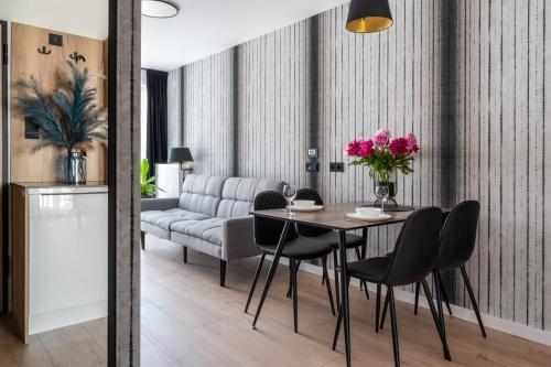 a dining room with a table and chairs and a couch at InPoint Central Apartments in Kraków