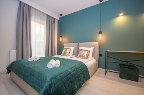 a bedroom with a bed with two towels on it at InPoint Central Apartments in Kraków
