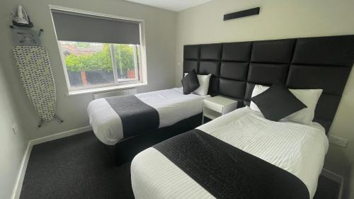 a hotel room with two beds and a window at Hosted By Ryan - 2 Bedroom Apartment in Liverpool