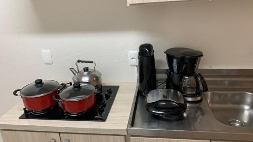 a kitchen counter with two pots and pans on a stove at Dom Ângelo Hospedagem in Bento Gonçalves