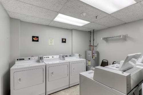 a laundry room with three washing machines and a sink at Sugar Top 2524 in Sugar Mountain