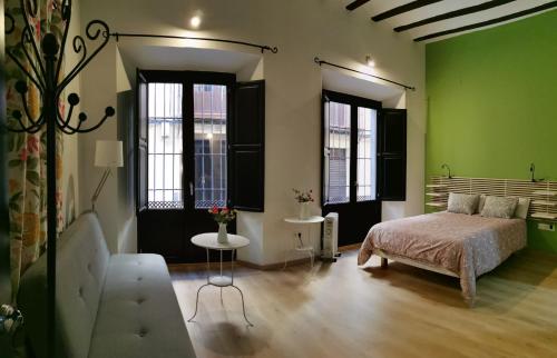 una camera da letto con pareti verdi, un letto e un tavolo di El Granado Hostel a Granada