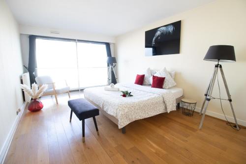ein Schlafzimmer mit einem Bett mit roten Kissen in der Unterkunft Appartement spacieux vue Cathédrale in Reims