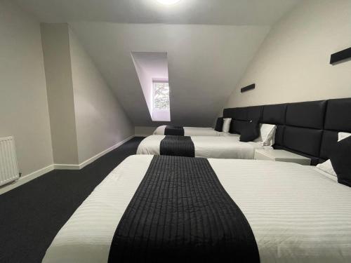 a attic bedroom with two beds and a window at Hosted By Ryan - 3 Bedroom Penthouse Apartment in Liverpool