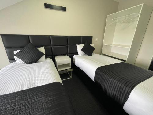 a hotel room with two beds and a chair at Hosted By Ryan - 3 Bedroom Penthouse Apartment in Liverpool