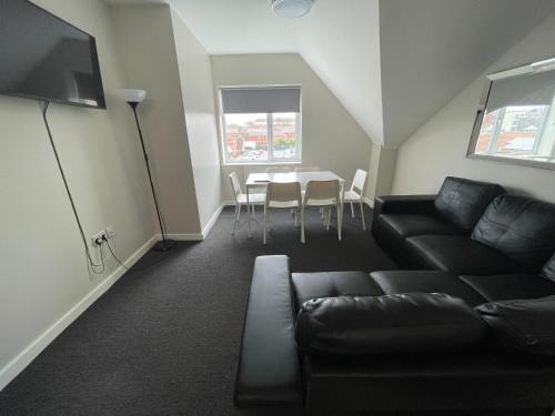 a living room with a couch and a table at Hosted By Ryan - 3 Bedroom Penthouse Apartment in Liverpool