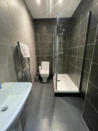 a bathroom with a shower and a toilet and a sink at Hosted By Ryan - 3 Bedroom Penthouse Apartment in Liverpool