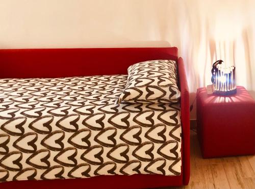 a bedroom with a bed with a red frame and a table at Gloria Holiday Home Bormio in Bormio
