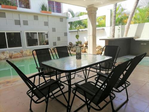 een tafel en stoelen op een patio met een zwembad bij Casa Rafaelita in Mérida