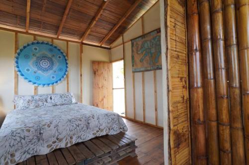 1 dormitorio con 1 cama y un plato azul en la pared en Charming - 2 Storey Eco-Home, en Olón