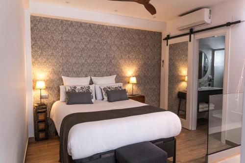 a bedroom with a large white bed and a bathroom at Mina50 by 7Escalones in Rota