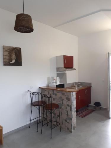 una cucina con 2 sedie e un bancone con piano cottura di Studio Cosy AFWA a Les Abymes