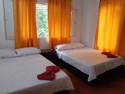 um quarto com duas camas com corações vermelhos em Laureana Hotel Campestre em Agua de Dios