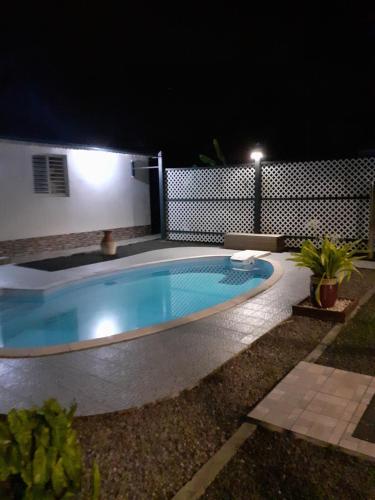 una piscina nel mezzo di un cortile di notte di Studio Cosy AFWA a Les Abymes