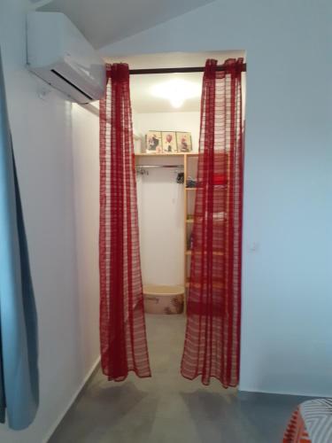 un pasillo con cortinas rojas en una habitación en Studio Cosy AFWA, en Les Abymes