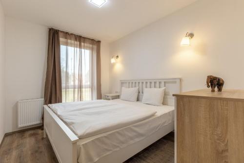 A bed or beds in a room at Fresh Green Wellness Apartman By BLTN Siófok