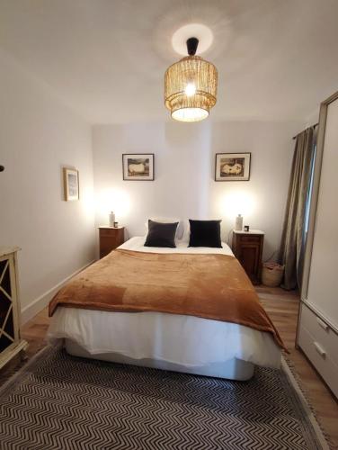 Un dormitorio con una cama grande y una lámpara de araña. en Artist Vintage Apartment near Center and Beaches en Esplugues de Llobregat