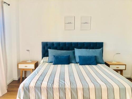 a bedroom with a large blue bed with blue pillows at Fantástico depto. con vistas panorámicas in Vicente López