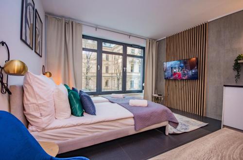 a bedroom with a large bed and a large window at InPoint Central Apartments in Kraków