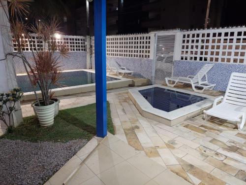 a patio with two chairs and a pool at night at CASA DA NINA in Tamandaré
