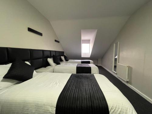 a hotel room with three beds in it at Hosted By Ryan - 4 Bedroom Penthouse Apartment in Liverpool
