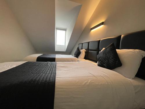 a hotel room with two beds and a window at Hosted By Ryan - 4 Bedroom Penthouse Apartment in Liverpool